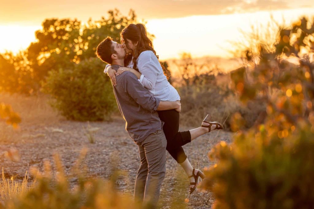 Thousand Oaks wedding photographer captures man lifting up his fiance as she kicks her leg up
