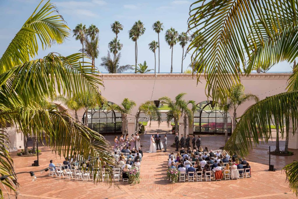 Santa Barbara wedding ceremony at the Hilton with palm trees, arches and stone paths for a truly elegant ceremony