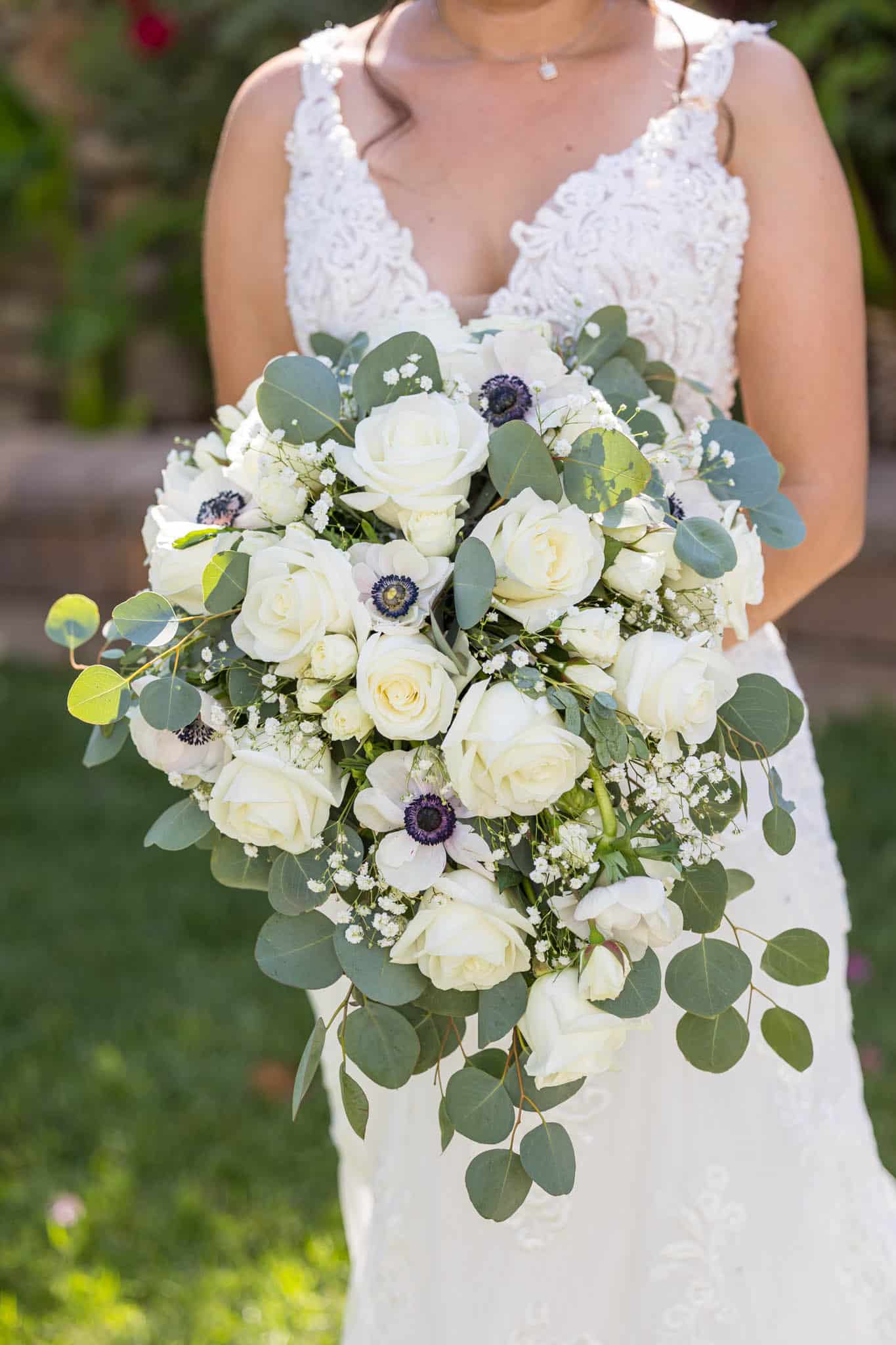 Ventura wedding photographer captures detail shot of bride's wedding bouquet with white roses and large eucalyptus leaves