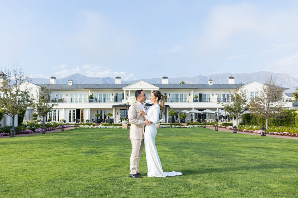 couple standing on the lawn in front of the rosewood miramar santa barbara wedding venue