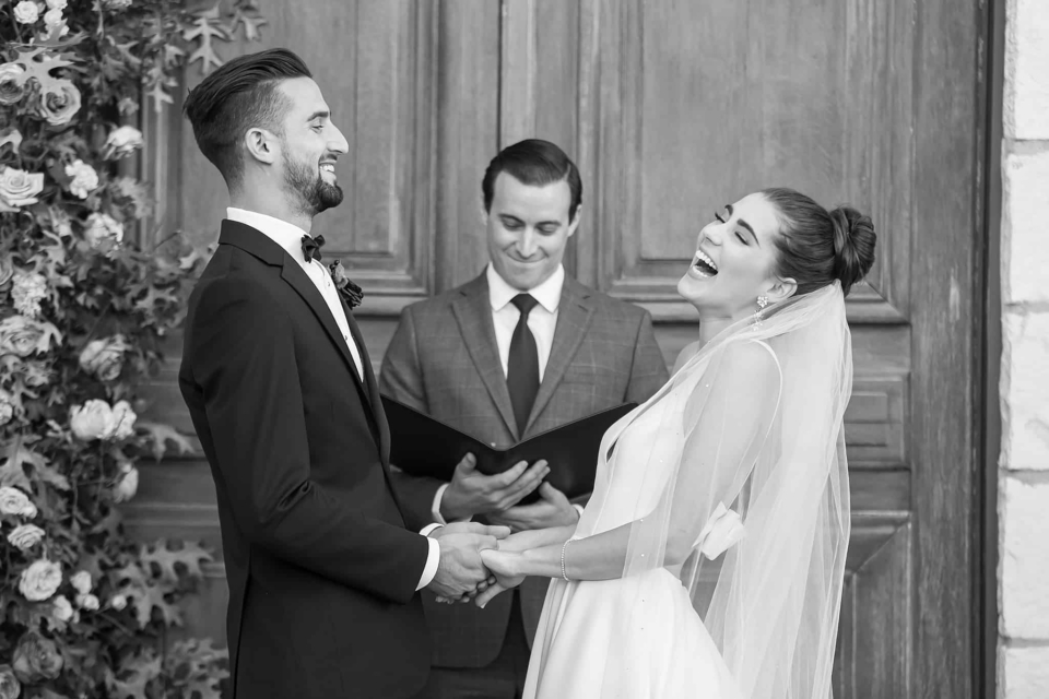 Bride and groom laughing during their vineyard wedding ceremony by santa barbara wedding photographer