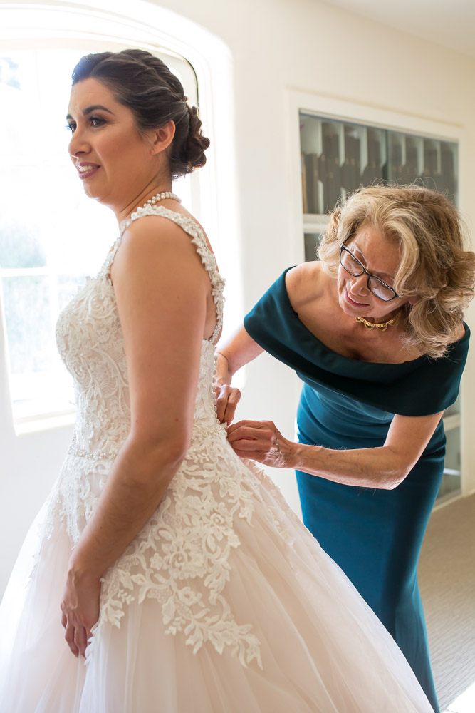 mom buttoning brides dress wedding photography